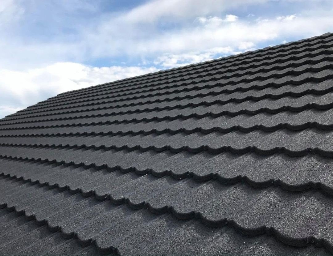 Interlocking stone-coated metal roof panels, overlapping courses